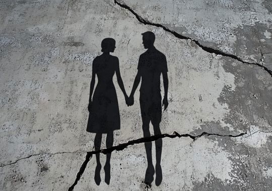 צללית של זוג מחזיק ידיים על רקע של משטח אפור עם שטחים